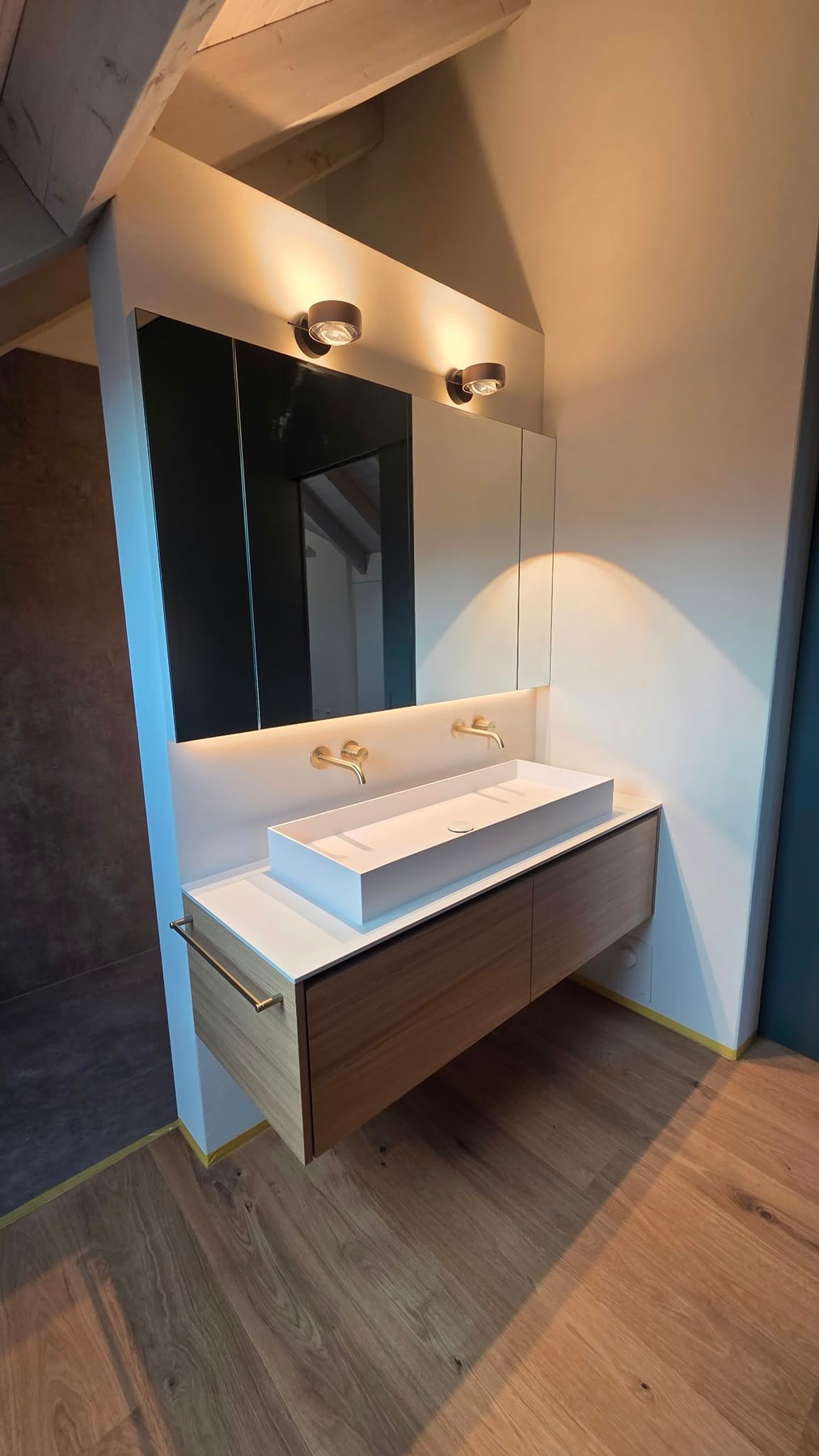 Waschtisch mit zwei Wandarmaturen und beleuchtetem Spiegelschrank