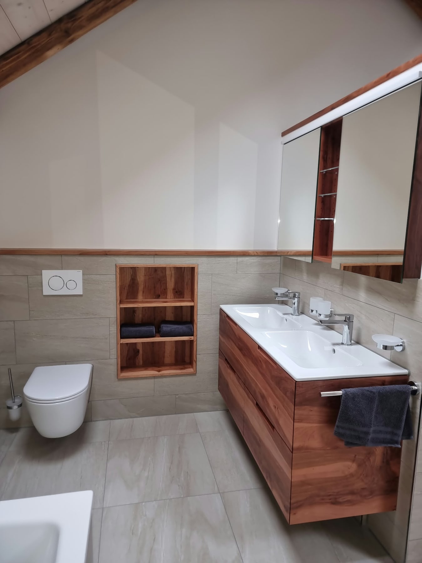 Badezimmer mit Doppelwaschtisch, Holzunterschrank und wandhängendem WC